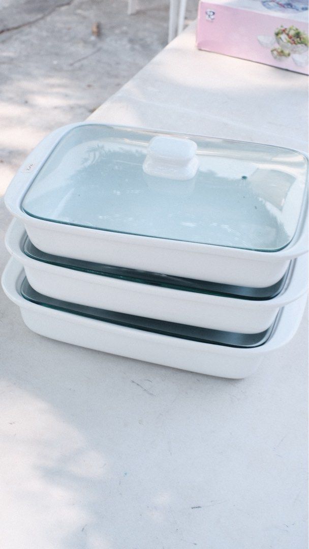 White Baking Dishes with Lids (Category: Bakeware) located in Las Pinas. Submitted by yourchaiboy (Listing ID 1430432132, Image 1). Description: Set of white rectangular baking dishes with glass lids. Includes three dishes stacked on top of each other. The lids have a white handle. The dishes appear to be clean and ready for use. Perfect for baking and serving..
