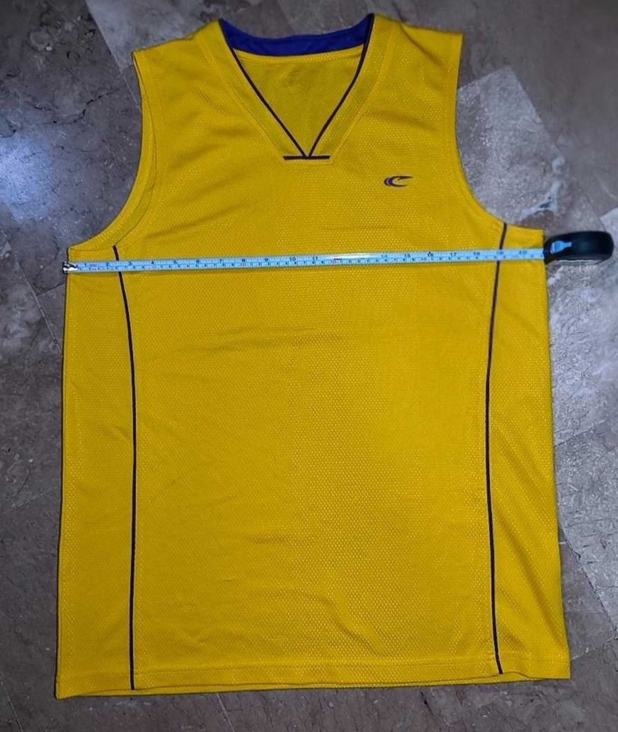 Yellow Sleeveless Tank Top (Category: Sleeveless) located in Caloocan City. Submitted by makyojs (Listing ID 1430545777, Image 1). Description: Yellow sleeveless tank top with a V-neck design. Features a small logo on the chest. The tank top has navy blue accents along the sides and neckline. Measurements are shown in the images..