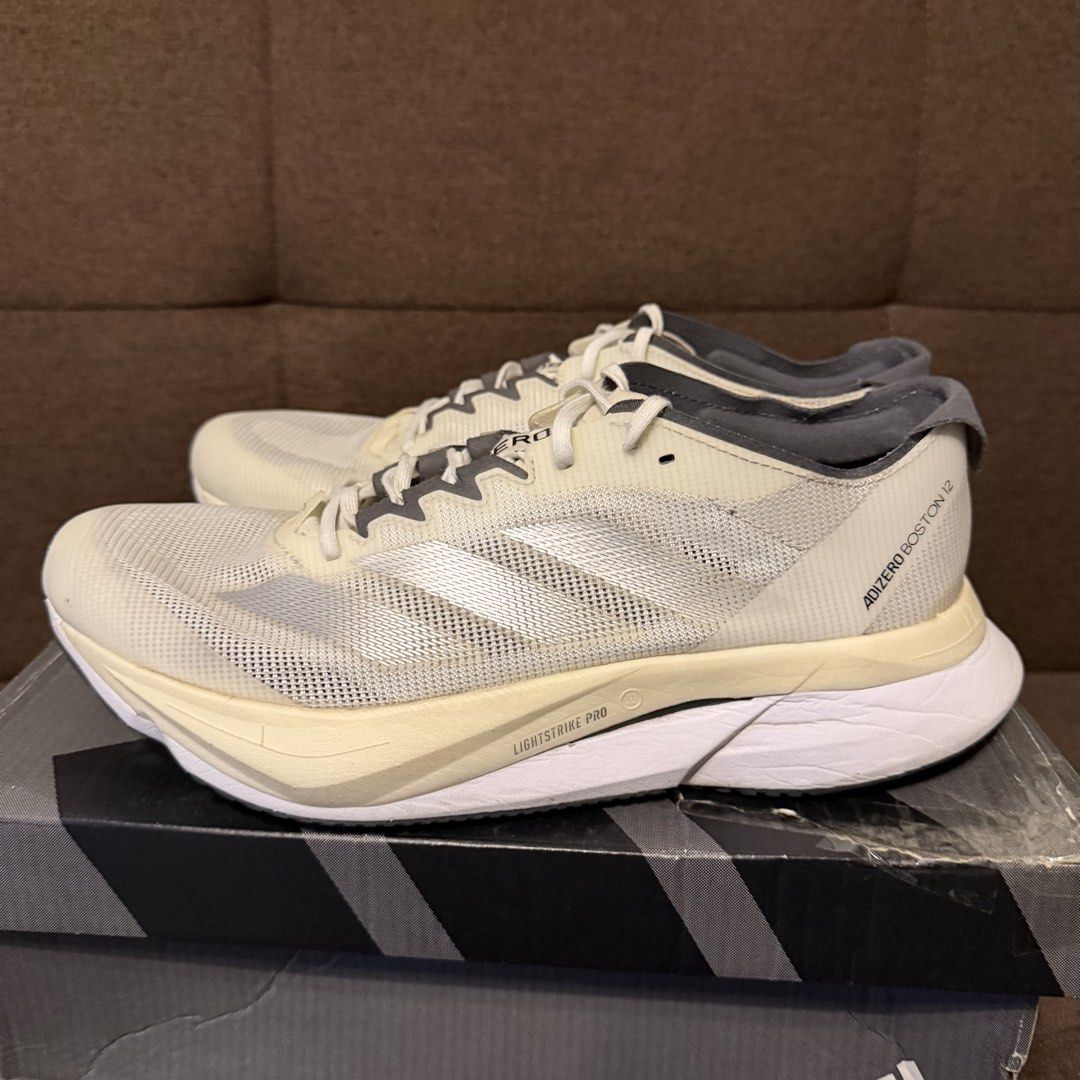 adidas adizero Boston 12 W (Category: Sneakers) located in Pasay City. Submitted by joshwhacker (Listing ID 1430773053, Image 3). Description: Adidas Adizero Boston 12 W running shoes. Features a cream and grey colorway with the Adidas logo on the side. The box indicates a size 9 US, 7 UK, and 260 JP. The shoes have a Lightstrike Pro midsole and Continental outsole. The shoes are in the original box (slightly damaged). .