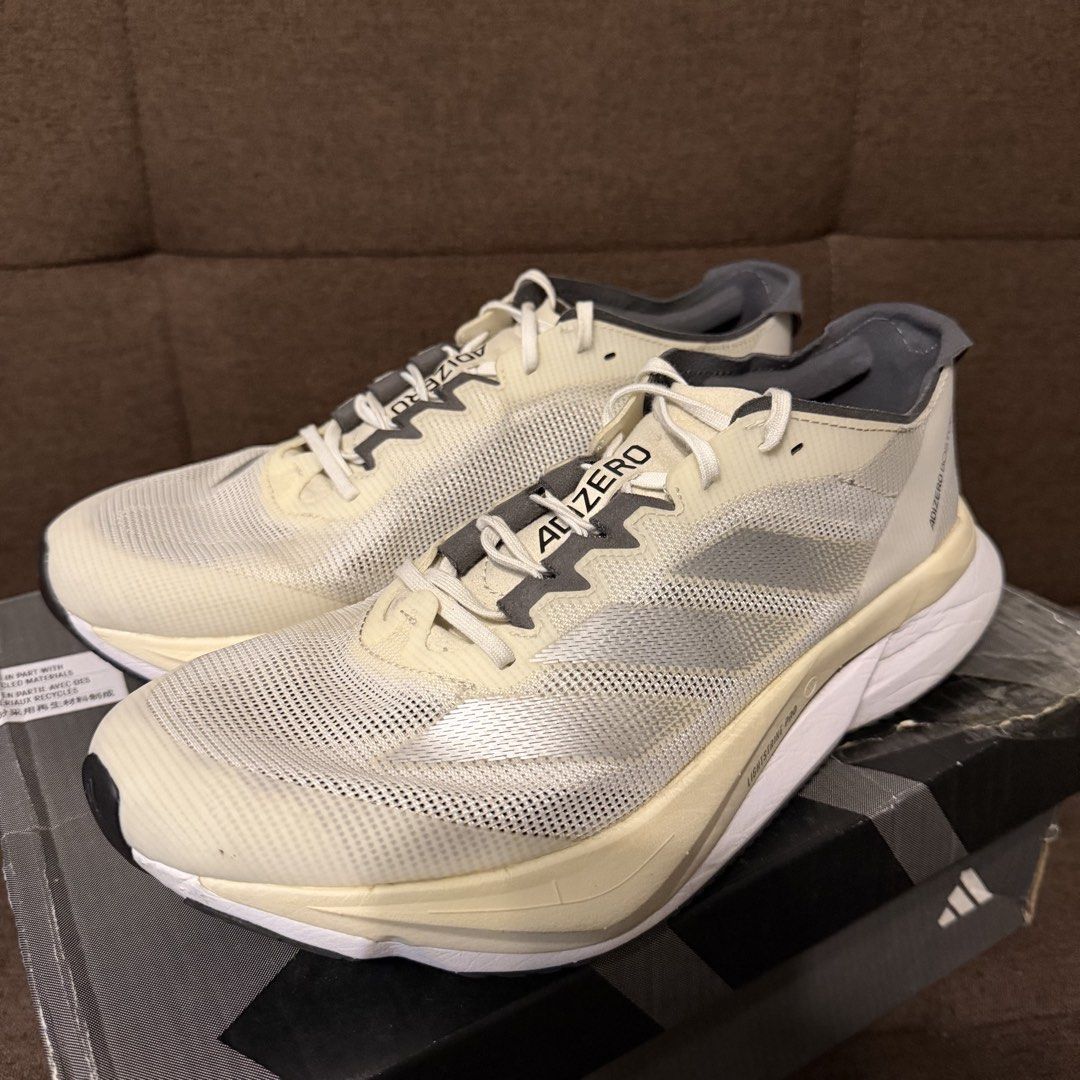 adidas adizero Boston 12 W (Category: Sneakers) located in Pasay City. Submitted by joshwhacker (Listing ID 1430773053, Image 1). Description: Adidas Adizero Boston 12 W running shoes. Features a cream and grey colorway with the Adidas logo on the side. The box indicates a size 9 US, 7 UK, and 260 JP. The shoes have a Lightstrike Pro midsole and Continental outsole. The shoes are in the original box (slightly damaged). .
