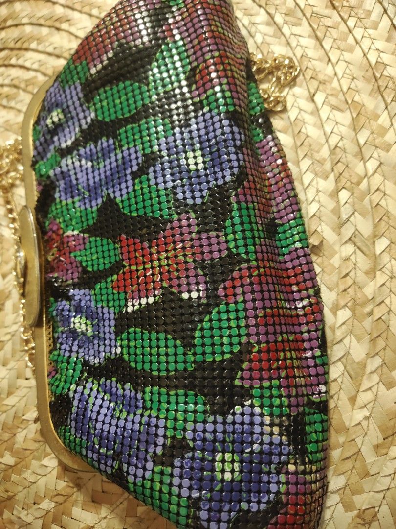 Arton Floral Clutch with Chain (Category: Clutches) located in Alaminos. Submitted by adornaura (Listing ID 1430611971, Image 3). Description: Elegant clutch bag by Arton, featuring a vibrant floral design. It has a gold-toned frame and a detachable chain strap. The interior is lined with black fabric and includes a zippered pocket. The bag's exterior showcases a mesh-like pattern with a mix of colors, adding a touch of vintage charm..
