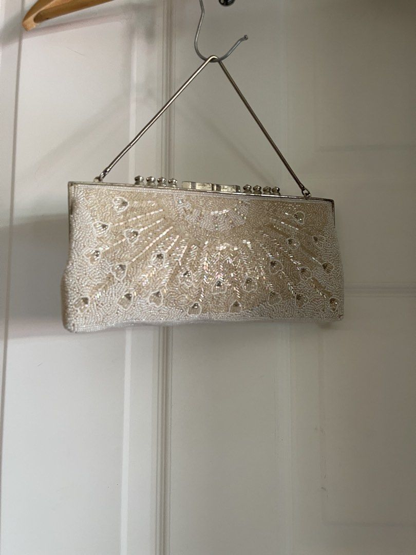 Beaded Clutch Bag with Silver Handle (Category: Clutches) located in Cagayan de Oro. Submitted by martinduarte22 (Listing ID 1430632646, Image 1). Description: Elegant clutch bag with intricate beadwork. Features a silver handle and a secure clasp closure. The bag is adorned with a detailed pattern of beads, creating a shimmering effect. Perfect for special occasions or evening events. The bag's design is both classic and eye-catching, making it 