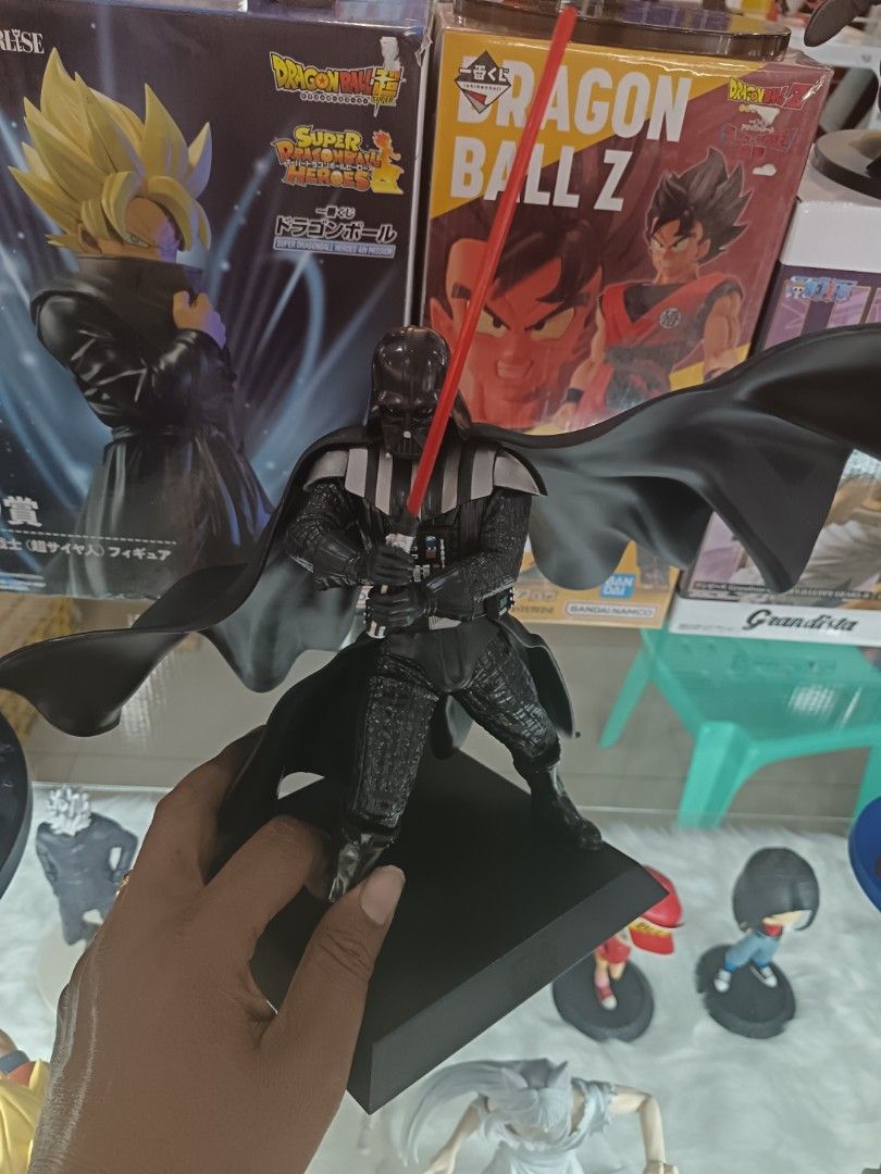 Darth Vader Figurine with Lightsaber (Category: Figurines & Statues) located in Manila. Submitted by wownawow (Listing ID 1430688260, Image 1). Description: Darth Vader figurine features the iconic Sith Lord holding his red lightsaber. The figurine is posed on a black base. It is a great addition to any Star Wars collection..