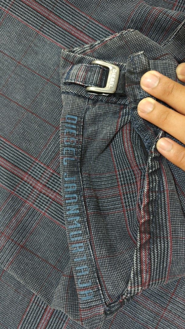 Diesel Plaid Pants (Category: Jeans) located in Bulacan. Submitted by thrifttoria1036372 (Listing ID 1430645020, Image 2). Description: Diesel plaid pants with a unique design. Features a button closure and a buckle detail. The pants have a gray and red plaid pattern. The tag indicates the pants are made of cotton and viscose. Waist line - 30-36 Thighs - 10 Leg opening - 9.5 Inseam - 31 Length - 41.