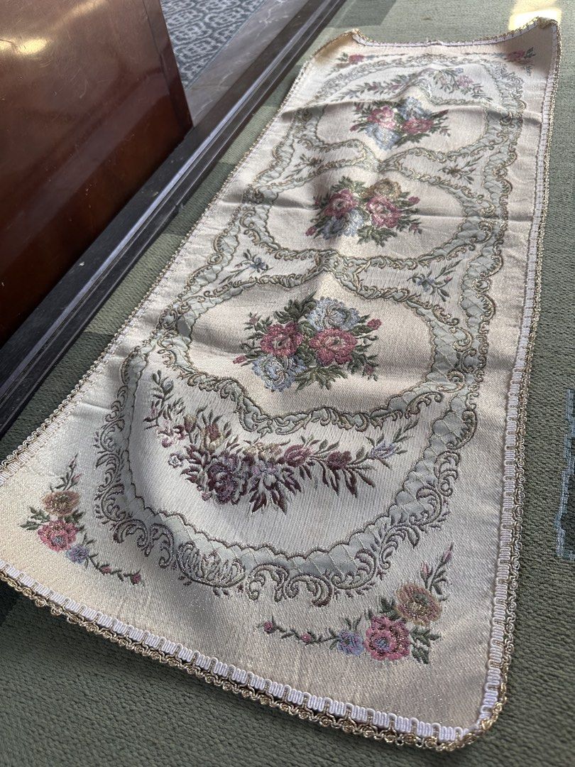 Floral Embroidered Table Runner (Category: Table Linen & Textiles) located in Digos. Submitted by puremountain.6f1756 (Listing ID 1430660464, Image 1). Description: Elegant table runner featuring a floral embroidered design. The runner has a cream-colored base with intricate floral patterns in shades of pink, blue, and purple. It is edged with a gold trim. The runner measures approximately 42 inches in length..