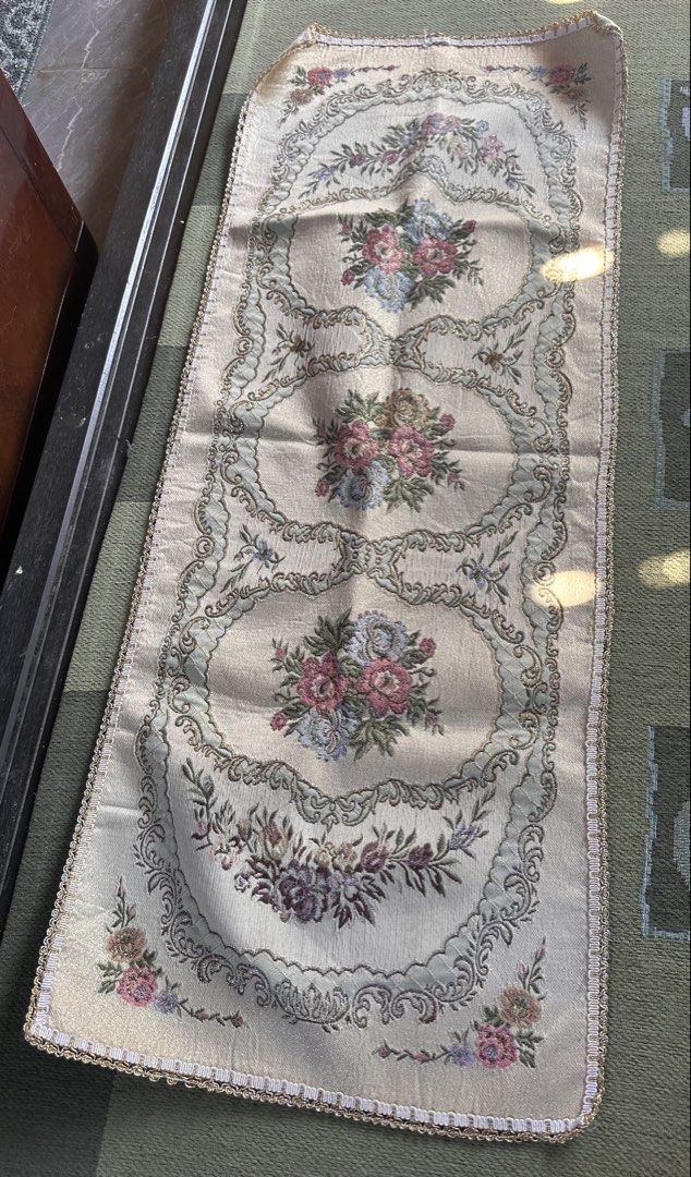 Floral Embroidered Table Runner (Category: Table Linen & Textiles) located in Digos. Submitted by puremountain.6f1756 (Listing ID 1430660464, Image 3). Description: Elegant table runner featuring a floral embroidered design. The runner has a cream-colored base with intricate floral patterns in shades of pink, blue, and purple. It is edged with a gold trim. The runner measures approximately 42 inches in length..