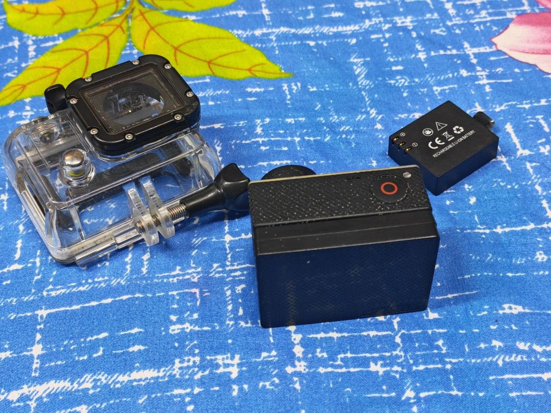 GoPro HERO3+ Action Camera (Category: Cameras) located in Manila. Submitted by ultimogizmos (Listing ID 1430614196, Image 3). Description: GoPro HERO3+ action camera with a waterproof housing, battery, and mounting hardware. The camera has a silver body with a black lens and buttons. The waterproof housing is clear with black accents. Includes a battery and a mounting screw. unit with 1 extended battery and 1 ordibary battery memory case no issue
