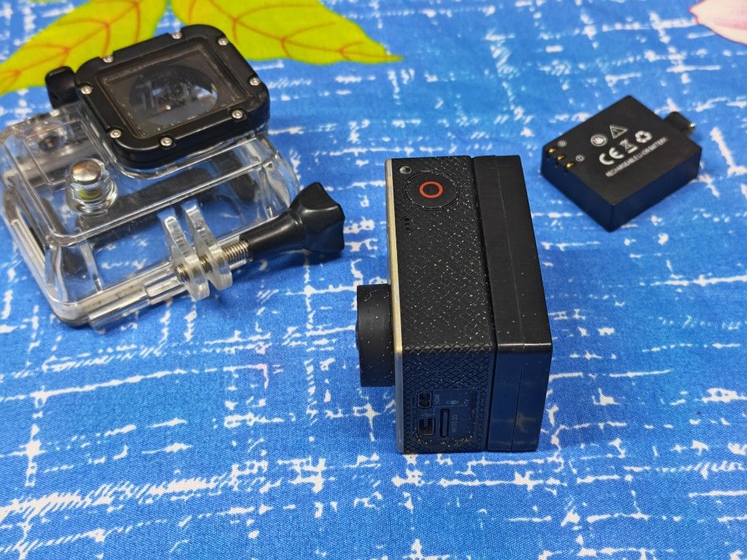GoPro HERO3+ Action Camera (Category: Cameras) located in Manila. Submitted by ultimogizmos (Listing ID 1430614196, Image 2). Description: GoPro HERO3+ action camera with a waterproof housing, battery, and mounting hardware. The camera has a silver body with a black lens and buttons. The waterproof housing is clear with black accents. Includes a battery and a mounting screw. unit with 1 extended battery and 1 ordibary battery memory case no issue