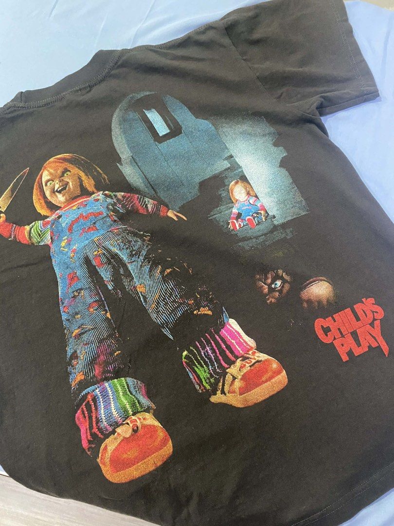 Hanes Chucky Child's Play Graphic Tee (Category: Tshirts & Polo Shirts ) located in Iloilo. Submitted by marctupas (Listing ID 1430775901, Image 2). Description: Black Hanes heavyweight t-shirt features a graphic print of Chucky from the Child's Play movie. The front showcases Chucky with a knife and the word "CHUCKY". The back has another Chucky graphic and the words "CHILD'S PLAY". Dimensions 22x28.
