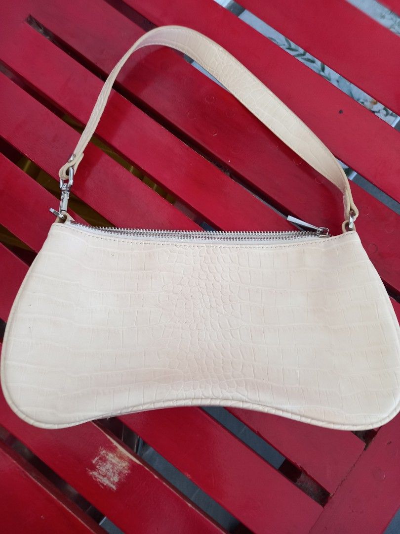 JW PEI Croc-Embossed Shoulder Bag (Category: Shoulder Bags) located in Tuguegarao City. Submitted by zenphoenix-7ad615 (Listing ID 1430643299, Image 1). Description: Shoulder bag features a unique, curved design with a croc-embossed finish. It has a zipper closure and a single shoulder strap. The interior includes a small pocket and a JW PEI label. The bag is in a light beige color. 10.5 by 5 inches.