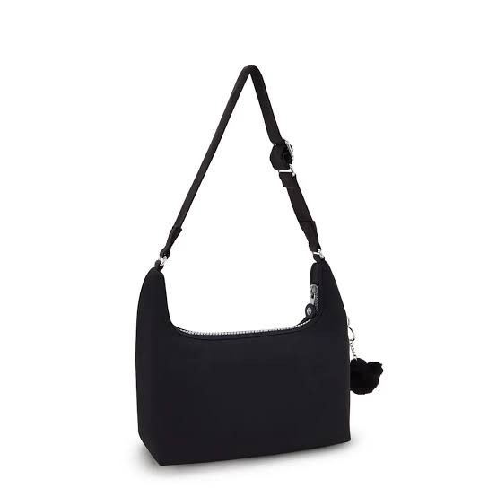 Kipling Nikki Shoulder Bag - Rapid Black (Category: Shoulder Bags) located in Davao. Submitted by jilly07 (Listing ID 1430613260, Image 3). Description: Kipling Nikki shoulder bag is in black. It features a main compartment with a zipper closure, and an adjustable shoulder strap. The bag includes a small Kipling monkey charm. It has a front zipper pocket and a Kipling logo patch. The bag is shown being worn over the shoulder. In excellent conditi
