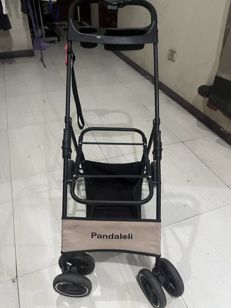 Pandaloli pet Stroller missing pet cage (Category: Strollers) located in Pasay City. Submitted by beye01 (Listing ID 1430607316, Image 1). Description: Pandaloli stroller features a black frame with a beige fabric panel. It has a storage basket and a tray with cup holders. The stroller has four sets of wheels. Missing pet cage. Stroller only. Foldable. Please check out my other items for sale. Thank you..