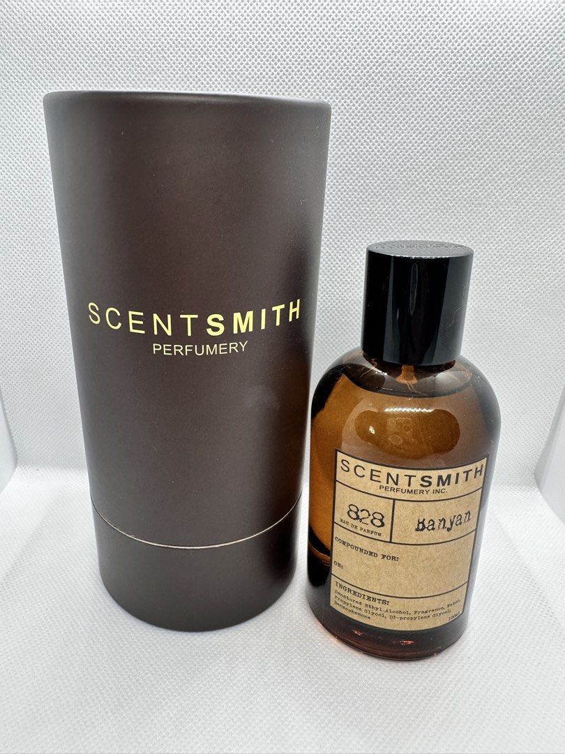 Scentsmith Perfumery 828 Banyan Eau de Parfum 100ml (Category: Fragrance & Deodorants) located in Taguig. Submitted by heytreasure (Listing ID 1430609023, Image 1). Description: Bottle of Scentsmith Perfumery 828 Banyan Eau de Parfum. The perfume comes in a brown glass bottle with a black cap and a cylindrical brown box. The box has the brand name "Scentsmith Perfumery" printed in gold. The label on the bottle indicates it is composed for "Banyan
