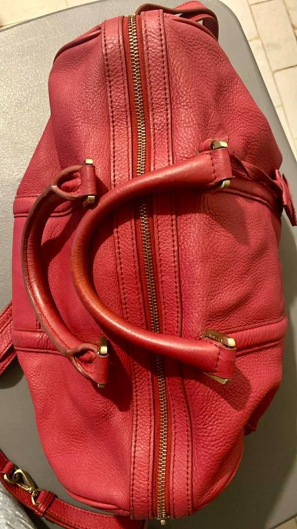 Sisley Red Leather Handbag (Category: Luxury Bags & Wallets) located in Marikina City. Submitted by imwondermum (Listing ID 1430704659, Image 3). Description: Red leather handbag from Sisley features a top handle and a detachable shoulder strap. It has a zip closure and gold-tone hardware. The interior is lined with red fabric and includes a small zippered pocket. The bag has a tag with the Sisley logo inside..