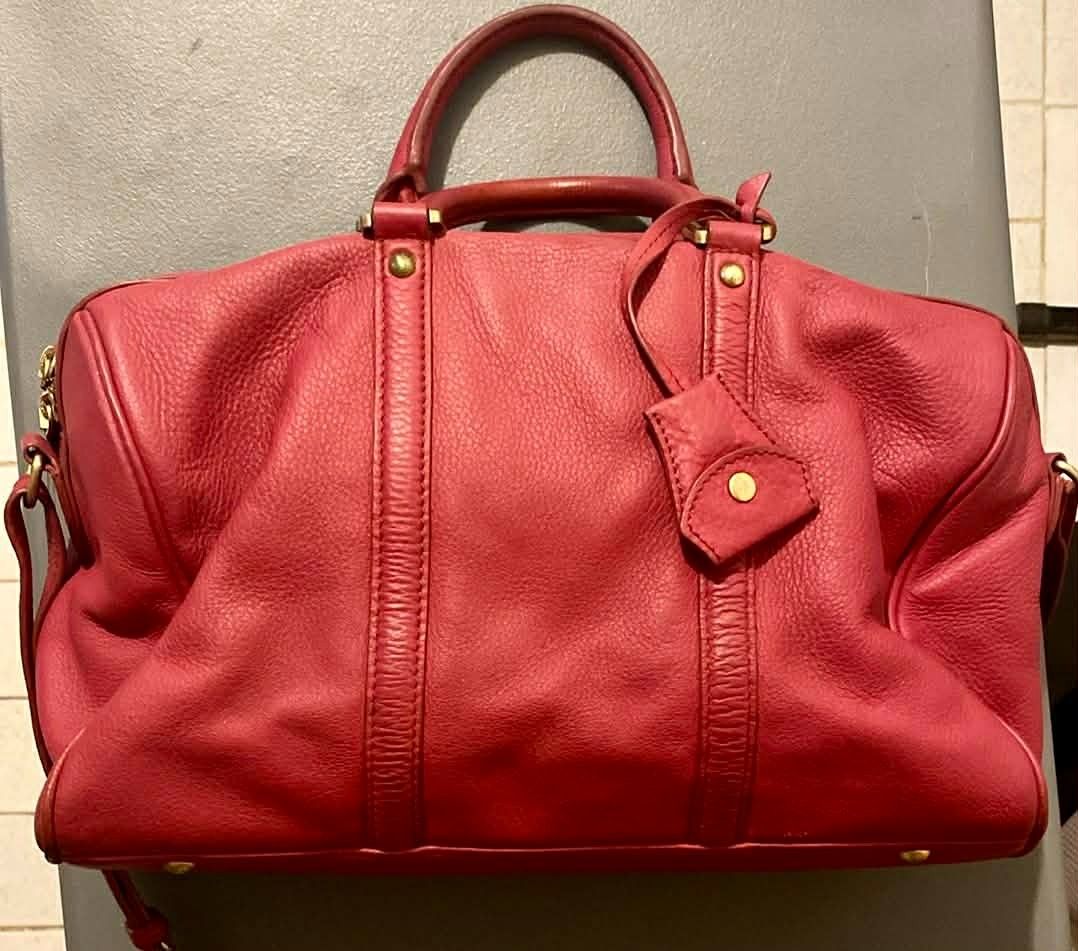 Sisley Red Leather Handbag (Category: Luxury Bags & Wallets) located in Marikina City. Submitted by imwondermum (Listing ID 1430704659, Image 1). Description: Red leather handbag from Sisley features a top handle and a detachable shoulder strap. It has a zip closure and gold-tone hardware. The interior is lined with red fabric and includes a small zippered pocket. The bag has a tag with the Sisley logo inside..