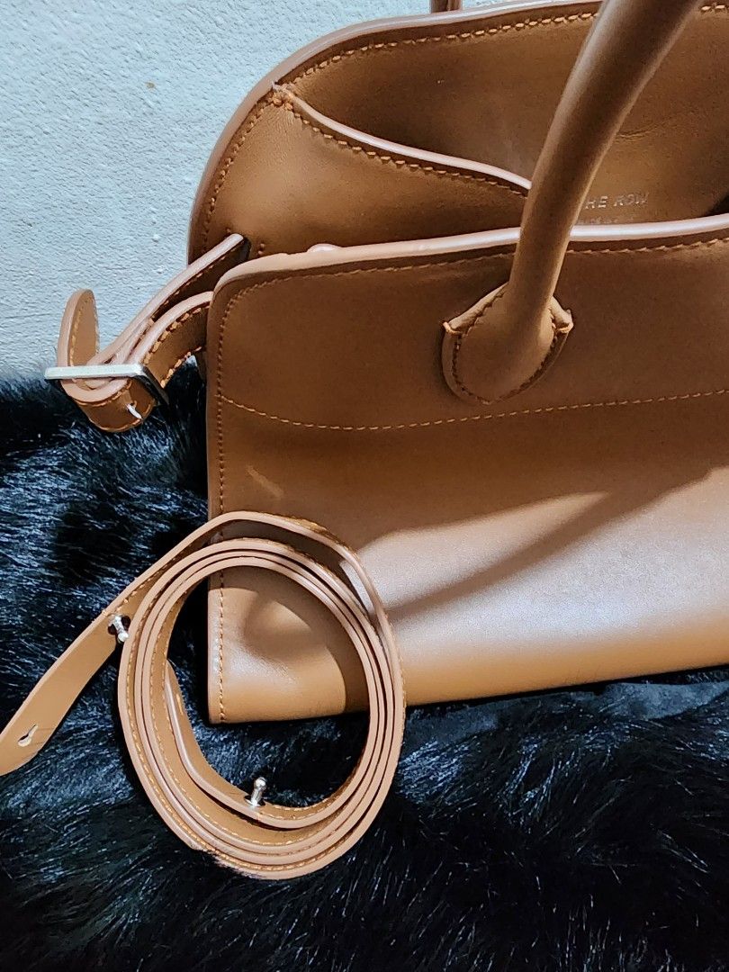 The Row - Margaux in Classic Brown (Category: Luxury Bags & Wallets) located in Cebu City. Submitted by avapaluca (Listing ID 1430771955, Image 2). Description: Beautiful leather handbag from The Row. Features a top handle design with an additional shoulder strap. The bag has a spacious interior with a zippered pocket. The exterior is a rich brown color with detailed stitching. The Row logo is visible on the interior and exterior hardware. Made i