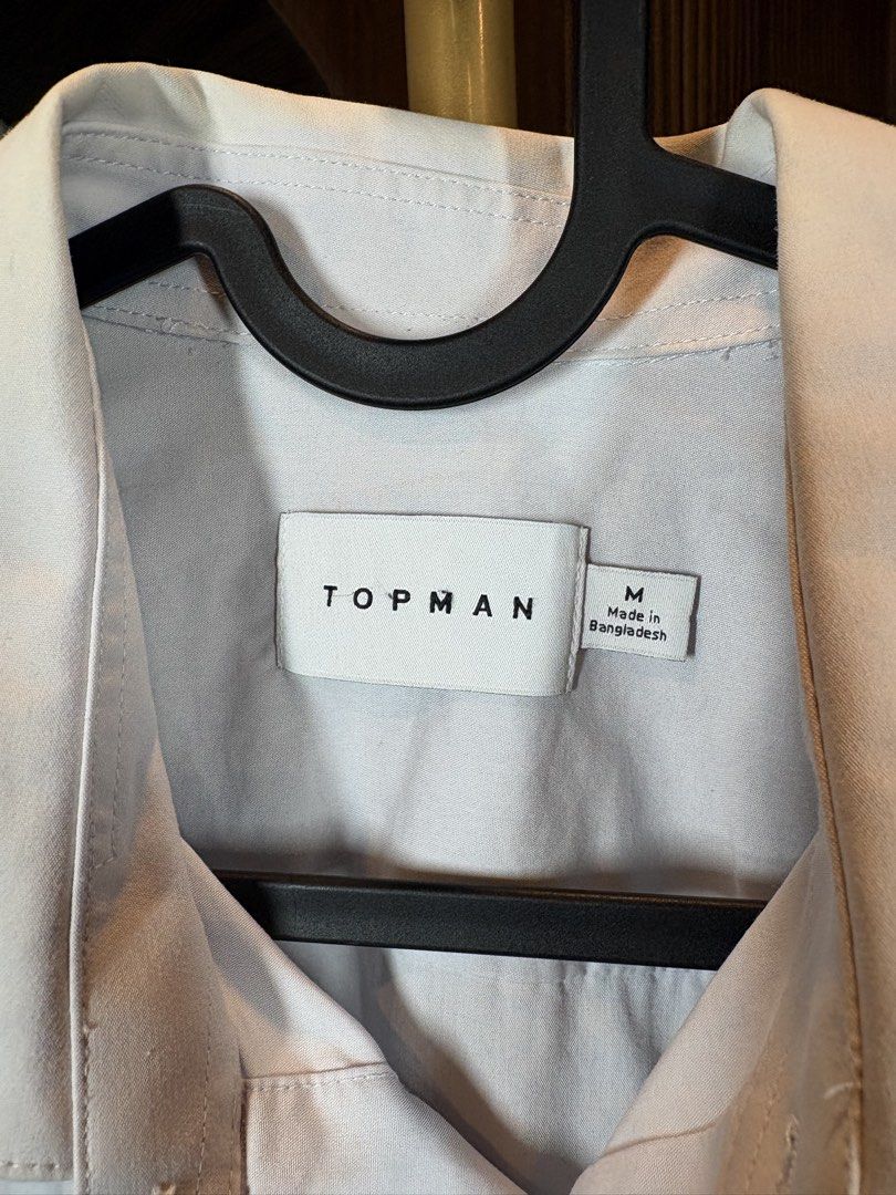 Topman Long Sleeve Shirt - Size M (Category: Tshirts & Polo Shirts ) located in Manila. Submitted by ccuadralaw (Listing ID 1430678160, Image 3). Description: Topman long sleeve shirt in a light grey color. It features a classic collar and button-down closure. The shirt is size M and made in Bangladesh. It is made of 64% Polyester and 4% Elastane. The care label indicates it can be machine washed..
