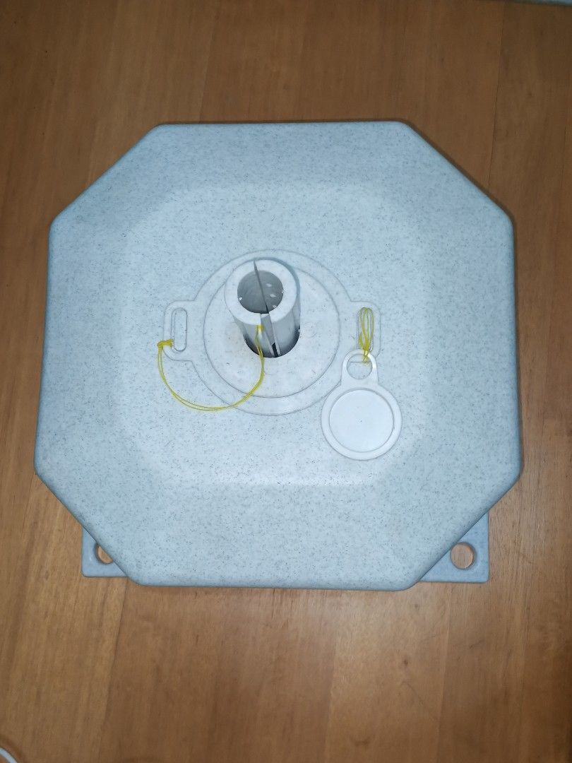 Umbrella Base (Category: Umbrellas) located in Caloocan City. Submitted by surplusandbnewshop (Listing ID 1430646827, Image 3). Description: - Sturdy umbrella base for outdoor use. - Octagonal design with four supporting legs for stability. - Includes a central pole holder and removable cap. - Made of a speckled, light-colored material. - Designed to securely hold a standard umbrella pole. - Easy to set up and use..