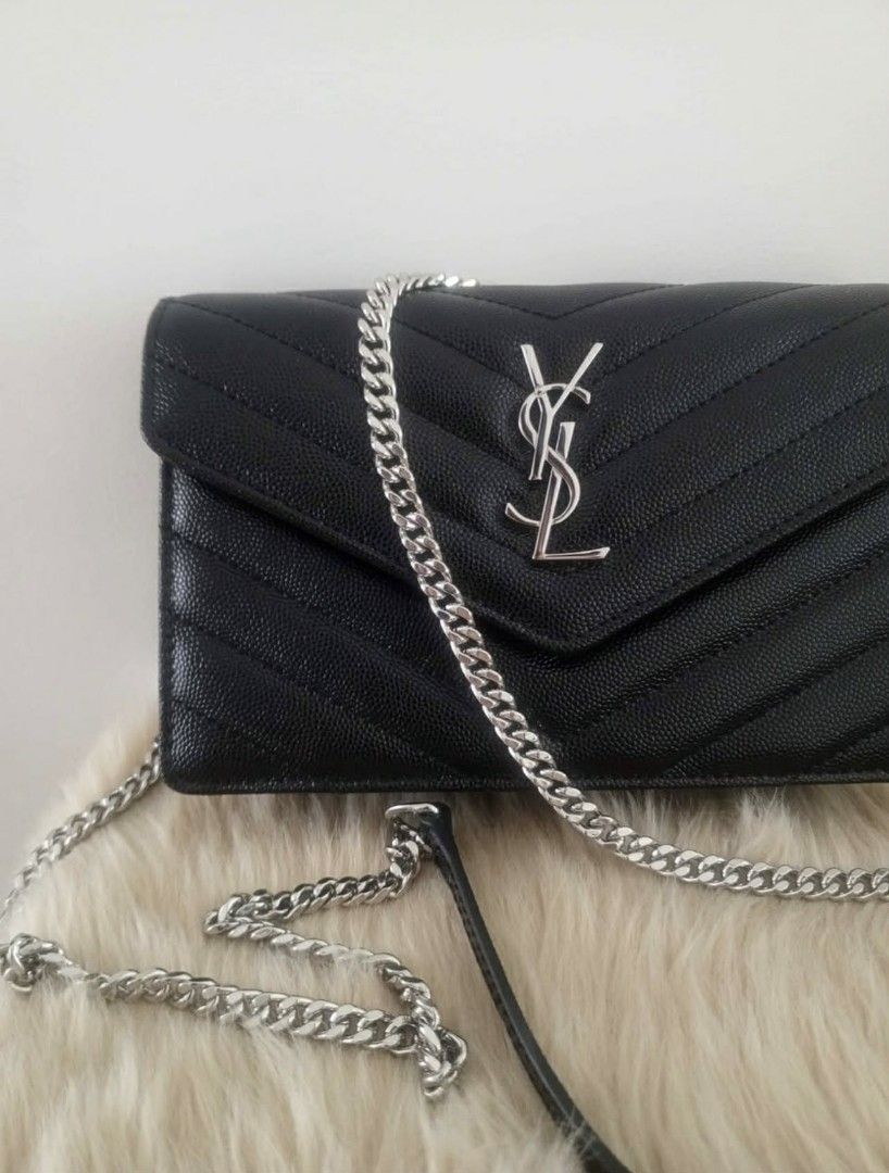 YSL Wallet on Chain Bag (Category: Luxury Bags & Wallets) located in Manila. Submitted by lanyklein (Listing ID 1430733417, Image 2). Description: Black YSL wallet on chain bag with silver-tone hardware. Features a chevron-quilted design and a chain strap. The interior includes multiple card slots and a zippered compartment. The bag is compact and suitable for carrying essentials. The YSL logo is prominently displayed on the front..