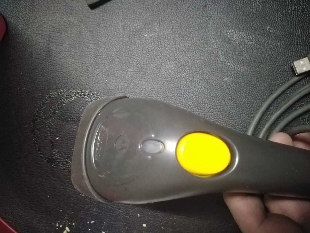 Zebra LS1203 Barcode Scanner (Category: Printers, Scanners & Copiers) located in Manila. Submitted by maybonifacio (Listing ID 1430694448, Image 3). Description: Zebra LS1203 barcode scanner. It has a USB connector and a long cable. The scanner has a yellow button and a gray body. The model number LS1203 is visible on the product label..