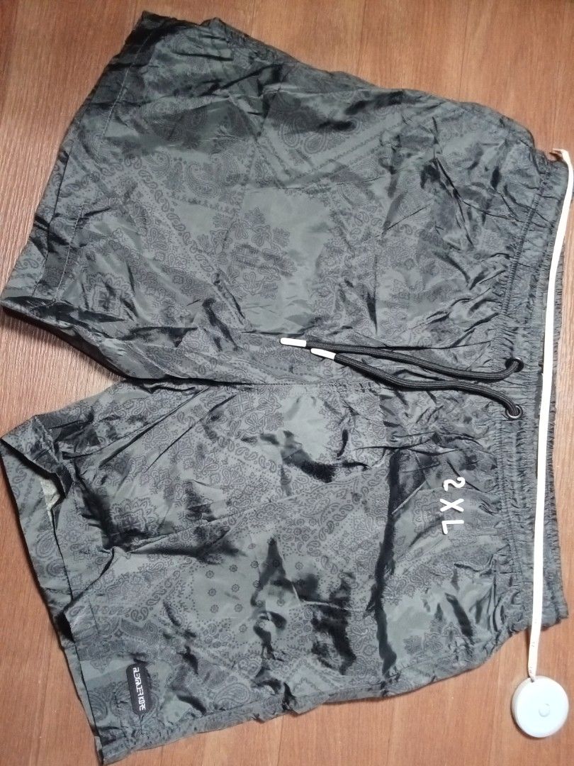 2XL Paisley Print Shorts (Category: Shorts) located in Makati City. Submitted by kuysman (Listing ID 1430835143, Image 1). Description: These shorts feature a paisley print design. They have a drawstring closure and a back pocket with a zipper. The size is 2XL. The shorts are a dark color, possibly gray or black. They appear to be made of a lightweight material. only sensible questions are entertained fits large stretchable 1 left .