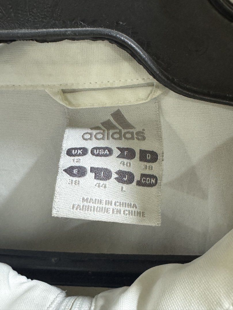 Adidas White Windbreaker Jacket with Navy Stripe (Category: Coats, Jackets and Outerwear) located in Bacoor. Submitted by brianluistro (Listing ID 1430872334, Image 2). Description: - Adidas windbreaker jacket - White with navy stripe design - Size: L - Perfect for casual wear or workouts.