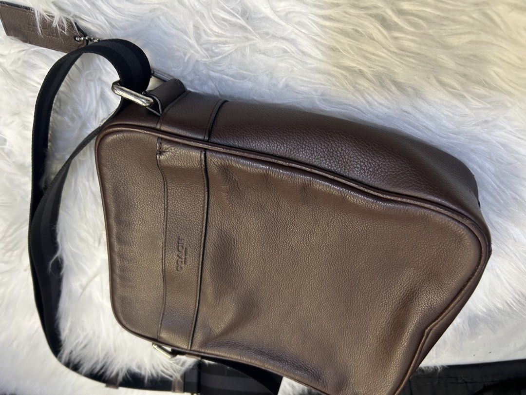 Coach Brown Leather Messenger Bag (Category: Luxury Bags & Wallets) located in Manila. Submitted by graceyabut0 (Listing ID 1430891575, Image 3). Description: Coach messenger bag is crafted from brown leather. It features a black adjustable strap and a zip closure. The interior includes a slip pocket and a Coach leather tag. The bag has a rectangular shape with a Coach logo on the front..