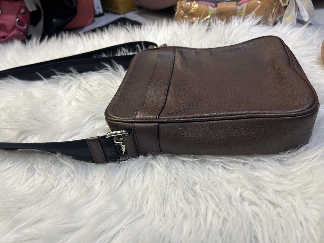 Coach Brown Leather Messenger Bag (Category: Luxury Bags & Wallets) located in Manila. Submitted by graceyabut0 (Listing ID 1430891575, Image 2). Description: Coach messenger bag is crafted from brown leather. It features a black adjustable strap and a zip closure. The interior includes a slip pocket and a Coach leather tag. The bag has a rectangular shape with a Coach logo on the front..
