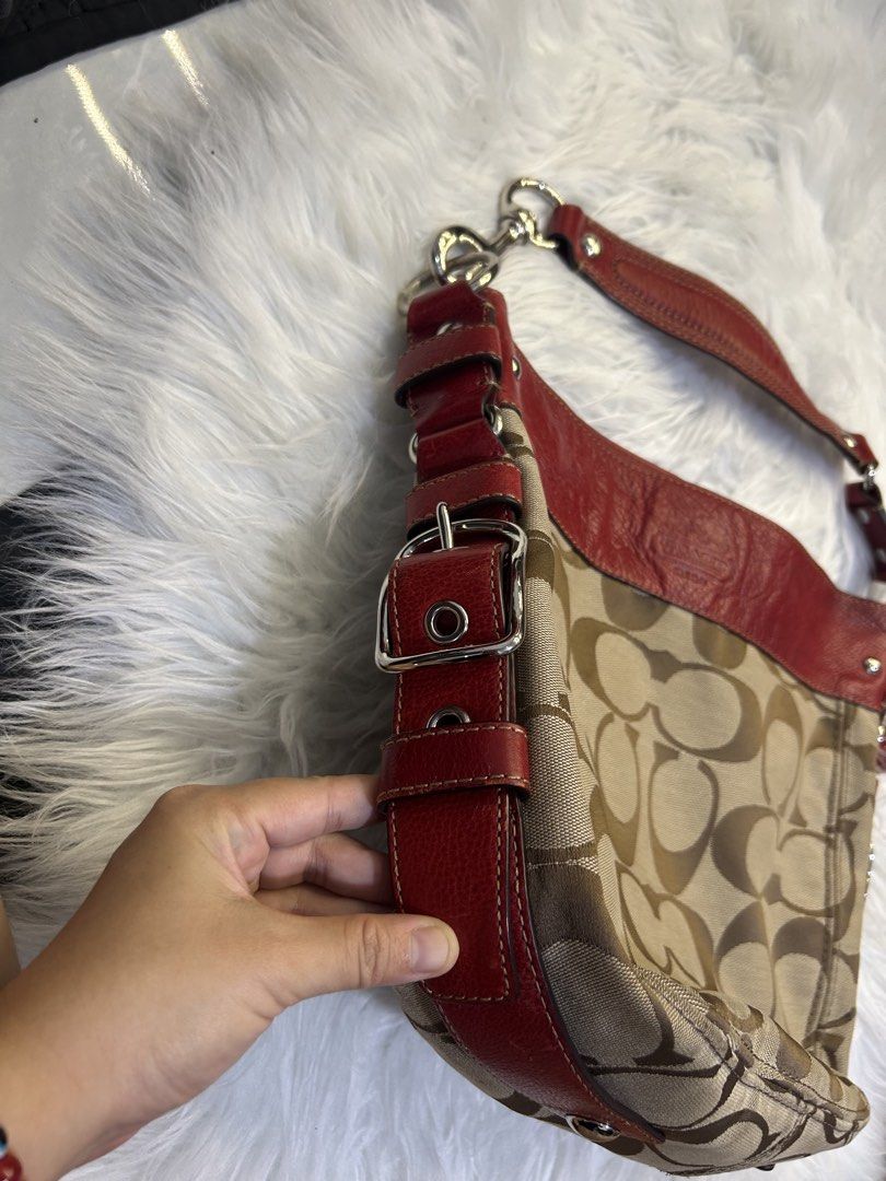 Coach Signature Hobo Bag (Category: Luxury Bags & Wallets) located in Manila. Submitted by graceyabut0 (Listing ID 1430890606, Image 2). Description: Coach signature hobo bag with red leather trim and accents. Features a classic Coach pattern in a neutral color. Includes a detachable cherry charm. The interior has multiple compartments. The bag has a shoulder strap and silver-tone hardware. The bag has a Coach tag attached..