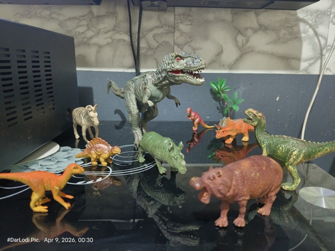 Dinosaur Toy Figures Set ( Take all) (Category: Action & Battle Toys) located in Pasay City. Submitted by mancave07 (Listing ID 1430962896, Image 1). Description: Set of dinosaur toy figures, including a T-Rex, Triceratops, and other prehistoric creatures. The T-Rex has red eyes and a detailed design. Made in China. Includes a zebra and a hippo figure. Great for kids or collectors at Bawal sa maselan..