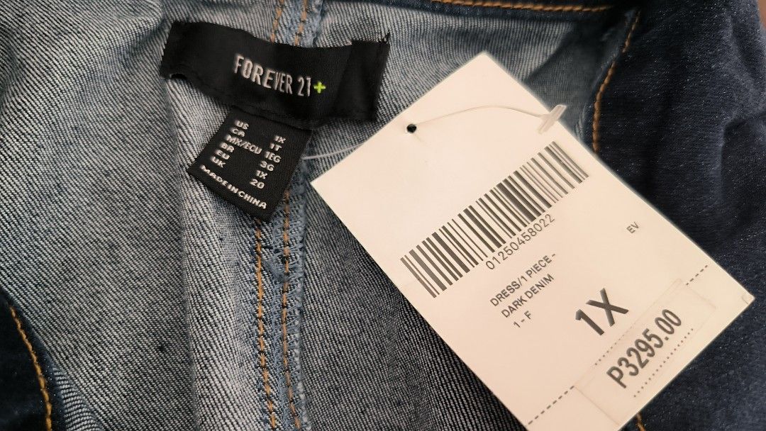 Forever 21+ Dark Denim Jumpsuit 1X (Category: Jumpsuits) located in Antipolo. Submitted by secondcharmstore (Listing ID 1430884705, Image 1). Description: sale 549 Forever 21+ dark denim jumpsuit. Features a collared neckline, short sleeves, and a full-length zipper. It has front pockets and decorative stitching details. The size is 1X. The original price tag is still attached. Made in China. chest: 42-44 inches waist: 36-40 inches length: 62 inc