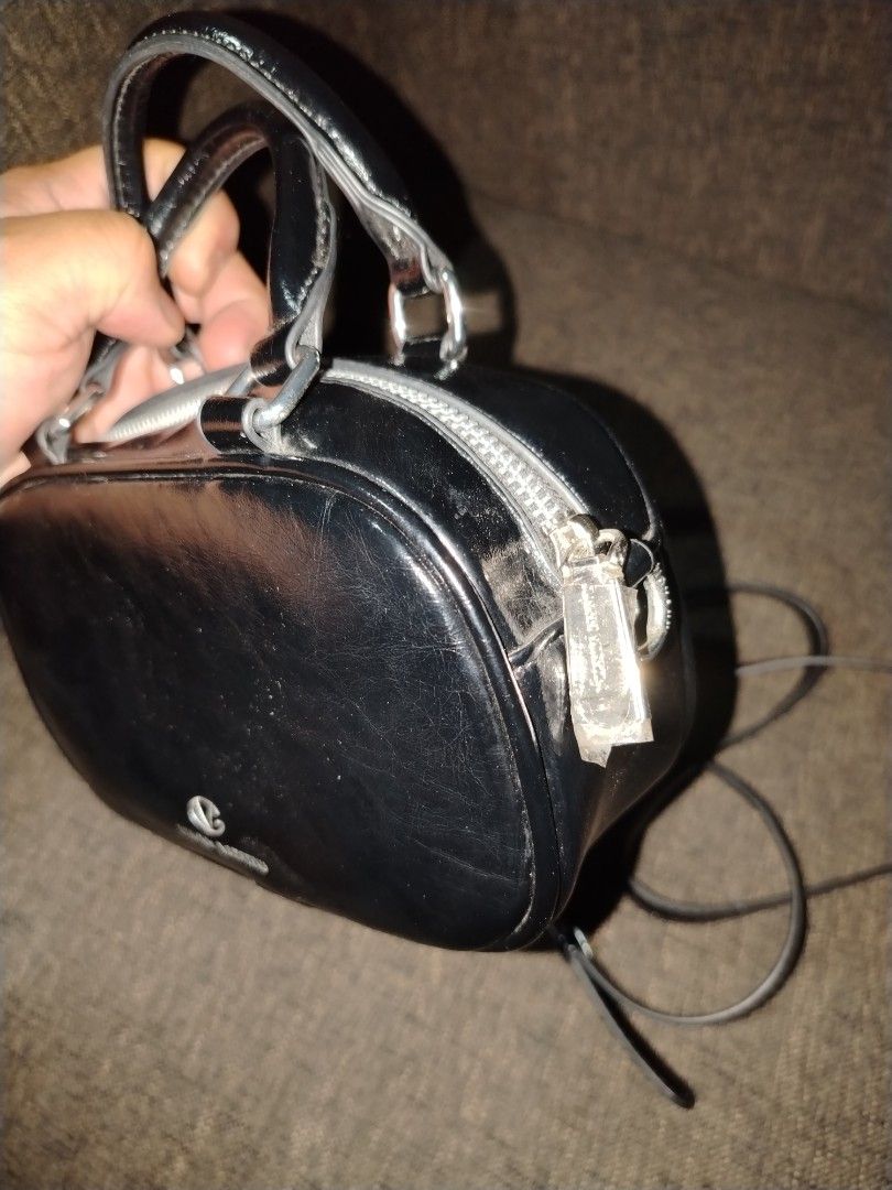 Giovanni Valentino Black Handbag with Strap (Category: Luxury Bags & Wallets) located in Munoz. Submitted by makie_ukay (Listing ID 1430935568, Image 3). Description: Black handbag by Giovanni Valentino. Features a top handle and a detachable shoulder strap. The bag has a silver zipper and hardware. The interior is lined with a light-colored fabric and includes a small pocket. The exterior has a prominent "VG" logo. Includes a small decorative de