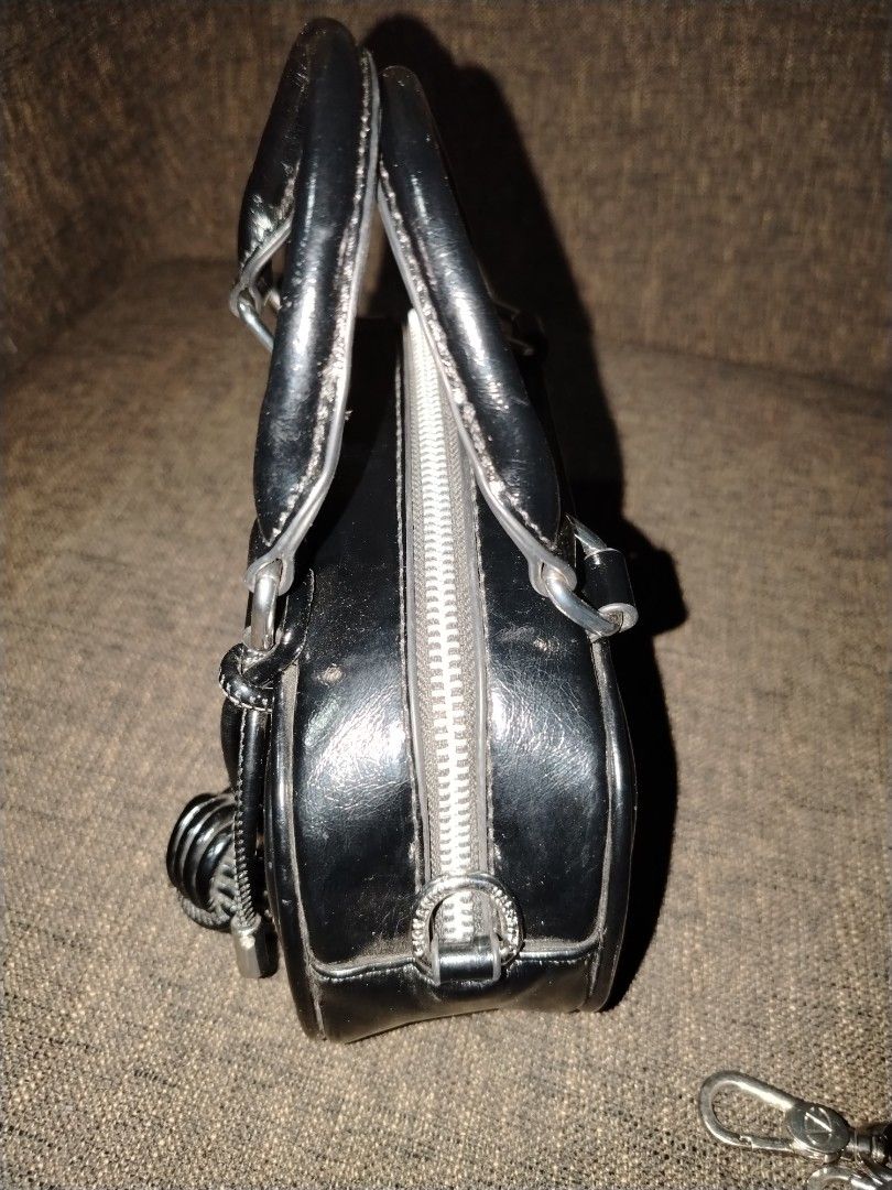 Giovanni Valentino Black Handbag with Strap (Category: Luxury Bags & Wallets) located in Munoz. Submitted by makie_ukay (Listing ID 1430935568, Image 2). Description: Black handbag by Giovanni Valentino. Features a top handle and a detachable shoulder strap. The bag has a silver zipper and hardware. The interior is lined with a light-colored fabric and includes a small pocket. The exterior has a prominent "VG" logo. Includes a small decorative de
