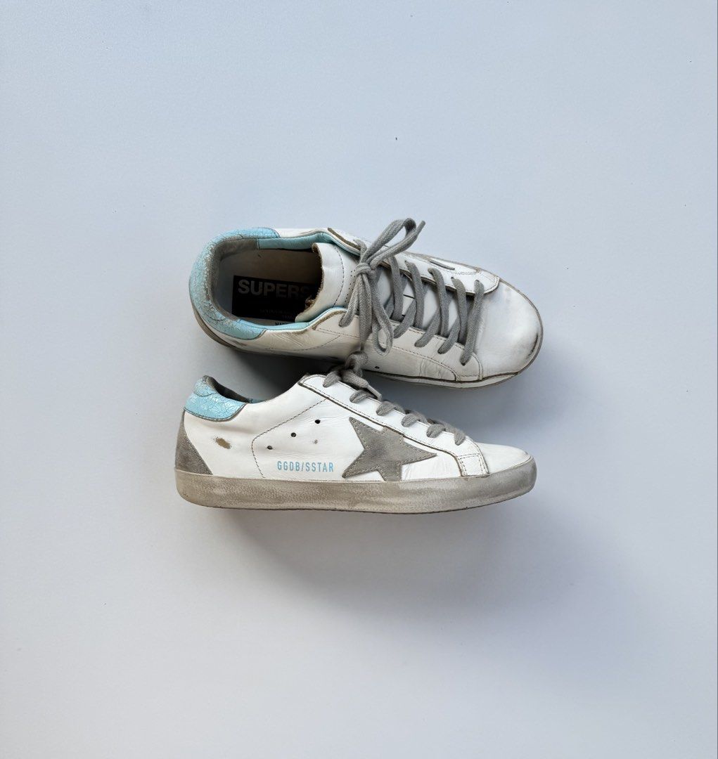 Golden Goose Superstar Sneakers (Category: Sneakers) located in Davao. Submitted by LUXURY (Listing ID 1430931976, Image 1). Description: Golden Goose Superstar sneakers in white with a grey star detail. Features a light blue heel tab Size 36 Pair only Visit my profile for more luxury items.