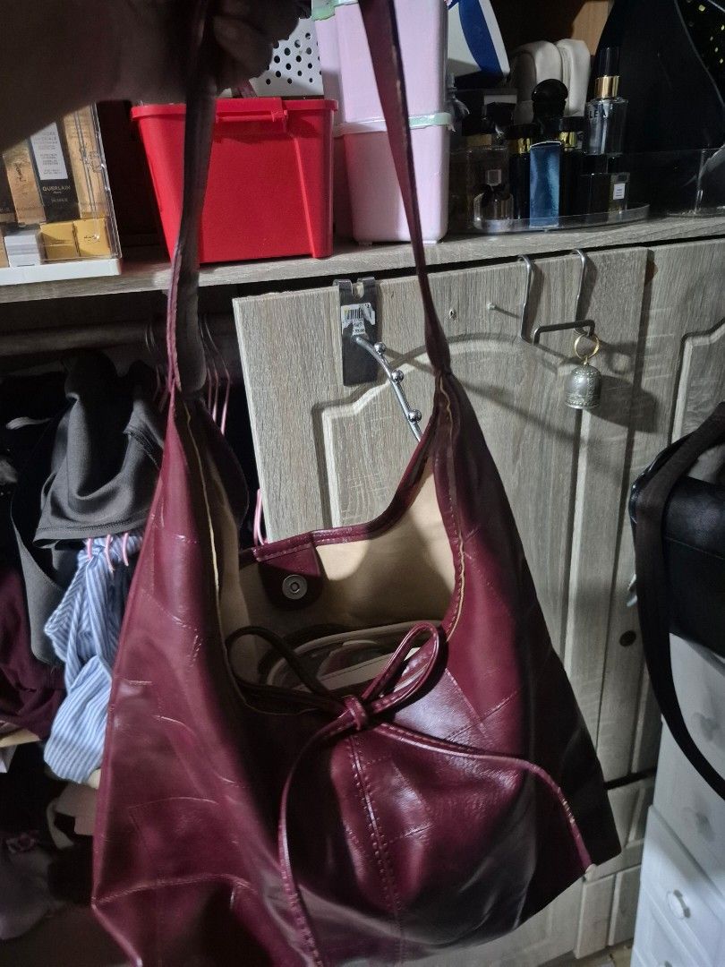 Maroon Shoulder Bag (Category: Shoulder Bags) located in Manila. Submitted by declutterwithpeanut (Listing ID 1430962764, Image 2). Description: Maroon shoulder bag with long straps. The interior lining is a lighter color. The straps show some wear. The bag has a simple, unstructured design..