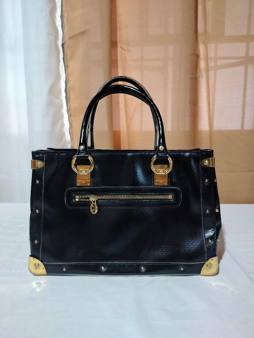 Metrocity Black Handbag (Category: Luxury Bags & Wallets) located in Marilao. Submitted by paadd (Listing ID 1430933490, Image 2). Description: Metrocity Italy brand Black patent leather with textured finish Good condition Price: 1100 Issue: Slight fading on the goldware at the bottom of the bag (visible in photo) Buyer shoulders the shipping fee Meet-up available for sure buyers only SM Marilao foodcourt.