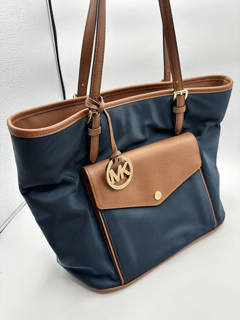 Michael Kors Navy Blue Tote Bag (Category: Luxury Bags & Wallets) located in Bocaue. Submitted by vs_luxuryfinds26 (Listing ID 1430829986, Image 1). Description: Php 4,000 Michael Kors Jet Set Nylon Leather Multifunction Pocket Tote Bag Condition: Very Good 🔍 Details: • Lightweight & durable nylon with leather trim • Spacious – perfect for work, travel, or everyday use • Multiple pockets for easy organization • Gold-tone hardware ✅ 100% Authenti