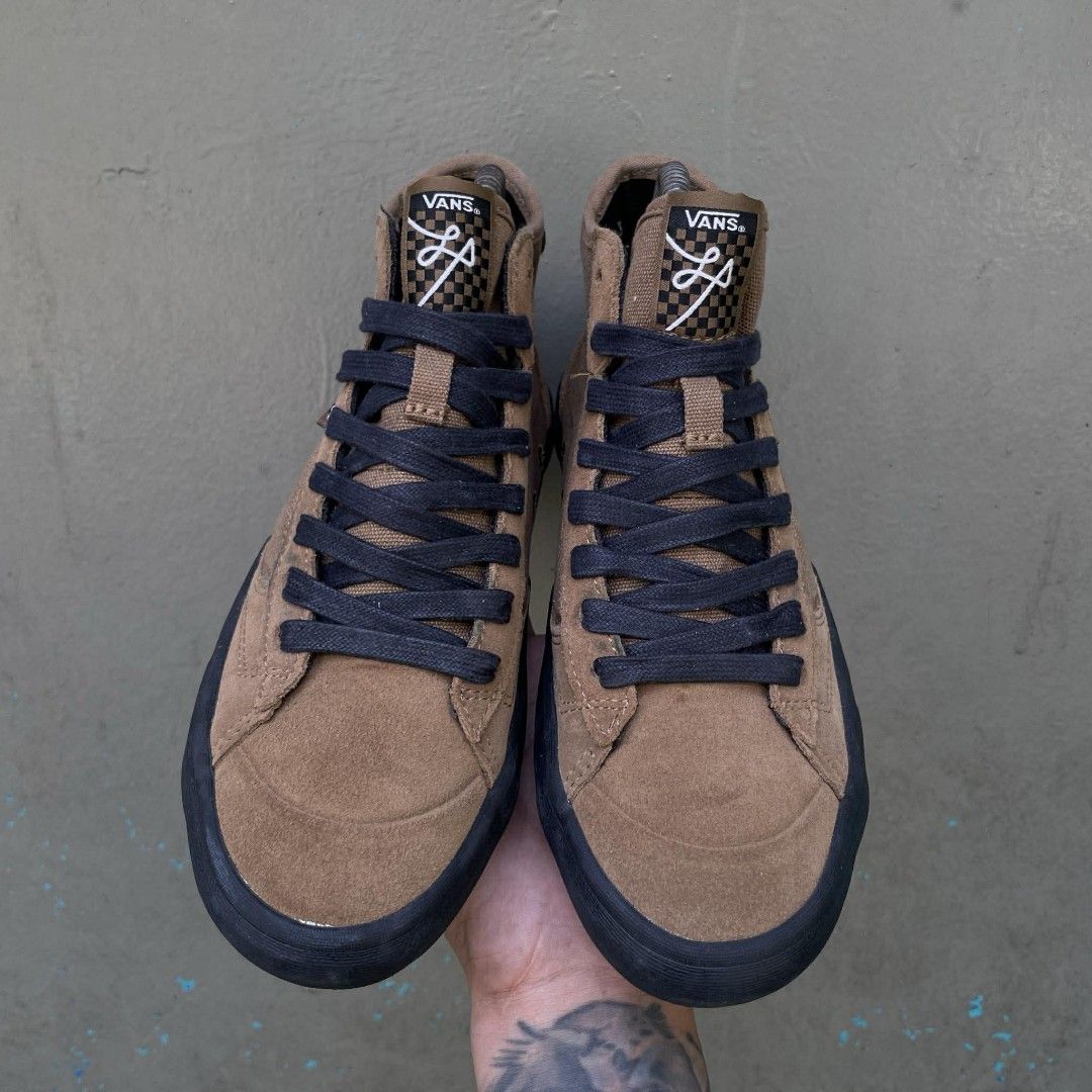 Vans Sk8-Mid Pro Skate Shoes (Category: Sneakers) located in Quezon City. Submitted by ibenta.ph (Listing ID 1430965030, Image 3). Description: Brown Vans Sk8-Mid Pro skate shoes with black soles and laces. Features the Vans logo on the side and "Off The Wall" branding on the heel. The shoes have a high-top design with a combination of suede and canvas materials. The tongue has a checkered pattern and a logo. Size 6.5 womens Excellent condition .