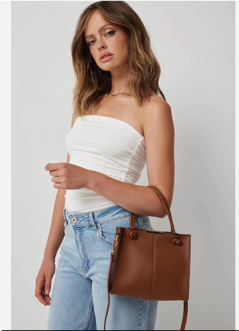 Zara Brown Handbag with Top Handles (Category: Luxury Bags & Wallets) located in Las Pinas. Submitted by ronabelles (Listing ID 1430883752, Image 1). Description: Zara handbag features a structured design with top handles and a detachable shoulder strap. It has a rectangular shape and a rich brown color. The bag includes knot details on the handles and a gold-tone hardware. The bag is suitable for everyday use. Decluttering Brandnew with tag 💙 Z