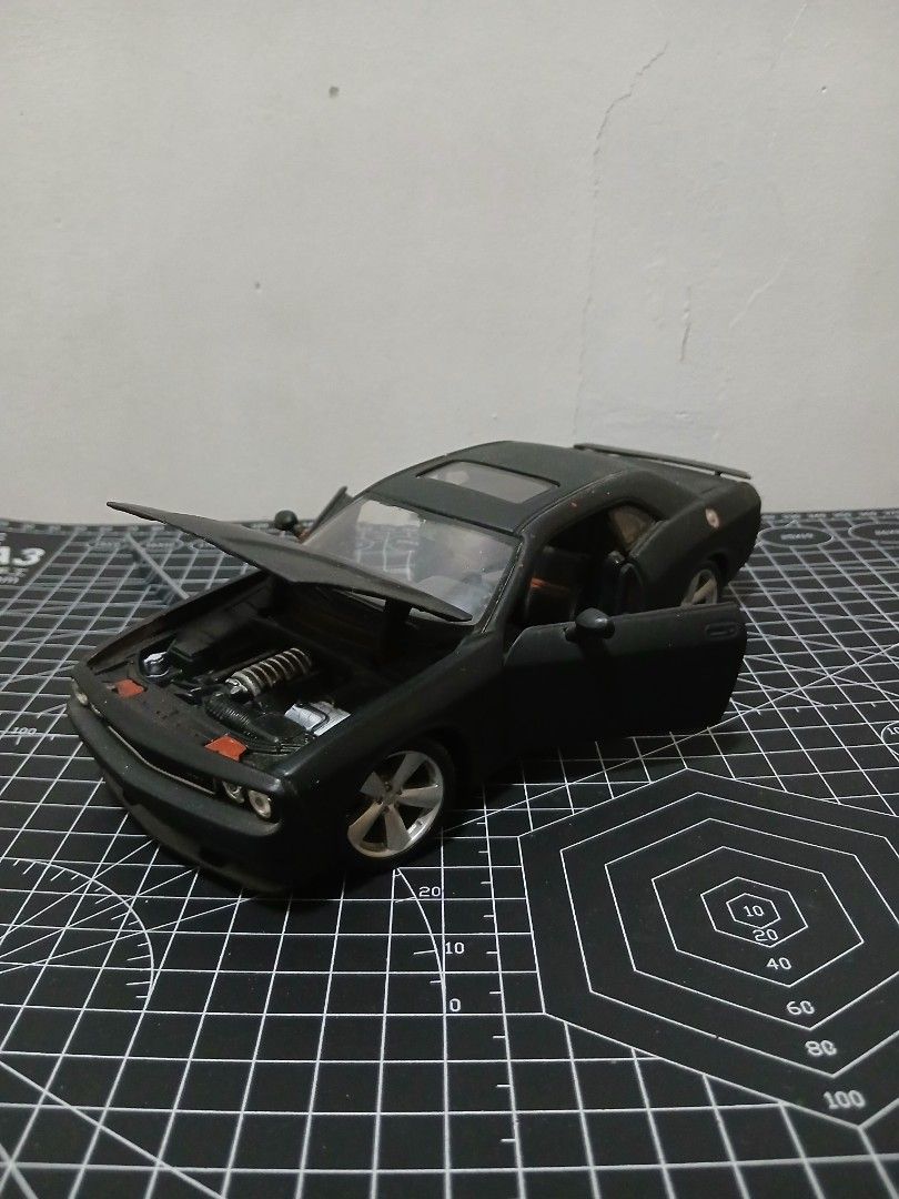 - Maisto 1/24 scale Dodge Challenger Diecast (Category: Vehicle & Diecast Models) located in Tanauan. Submitted by jeuskingz (Listing ID 1431171147, Image 1). Description: - Maisto 1/24 scale Dodge Challenger diecast. - Sleek black color. - Detailed interior and engine. - Paint Chips - Opening doors and hood. - Ideal for collectors and car enthusiasts. - Side Mirror Left Side Missing.