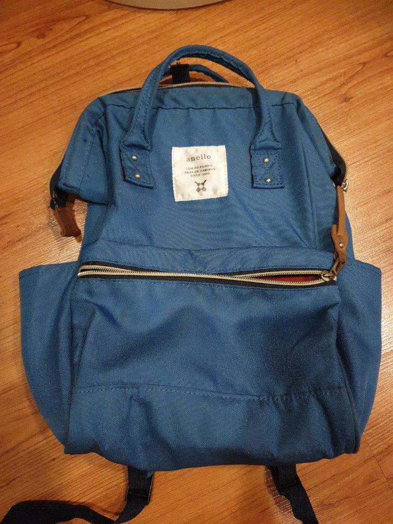 Anello Backpack - Blue (Category: Backpacks) located in Quezon City. Submitted by aredattic (Listing ID 1431067745, Image 1). Description: Blue Anello backpack with a spacious orange interior. Features a top handle and adjustable shoulder straps. Includes a front zipper pocket, 2 side pockets, and a main compartment zipper. The backpack has a small brand tag on the front. flaws: little stains and softened bag structure RFS: decluttering.