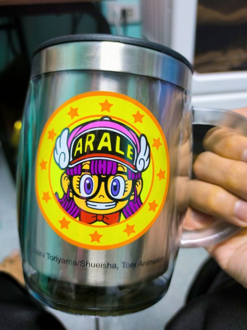 Arale Stainless Steel Mug with Lid (Category: Coffee & Tea Tableware) located in Caloocan City. Submitted by greenearth28555 (Listing ID 1431064070, Image 1). Description: Almost new. No box. Stainless steel mug features an Arale Norimaki design. It includes a lid and a clear handle. The mug has a double-walled design. Care instructions are included inside the mug. The bottom of the mug has a textured, non-slip surface..