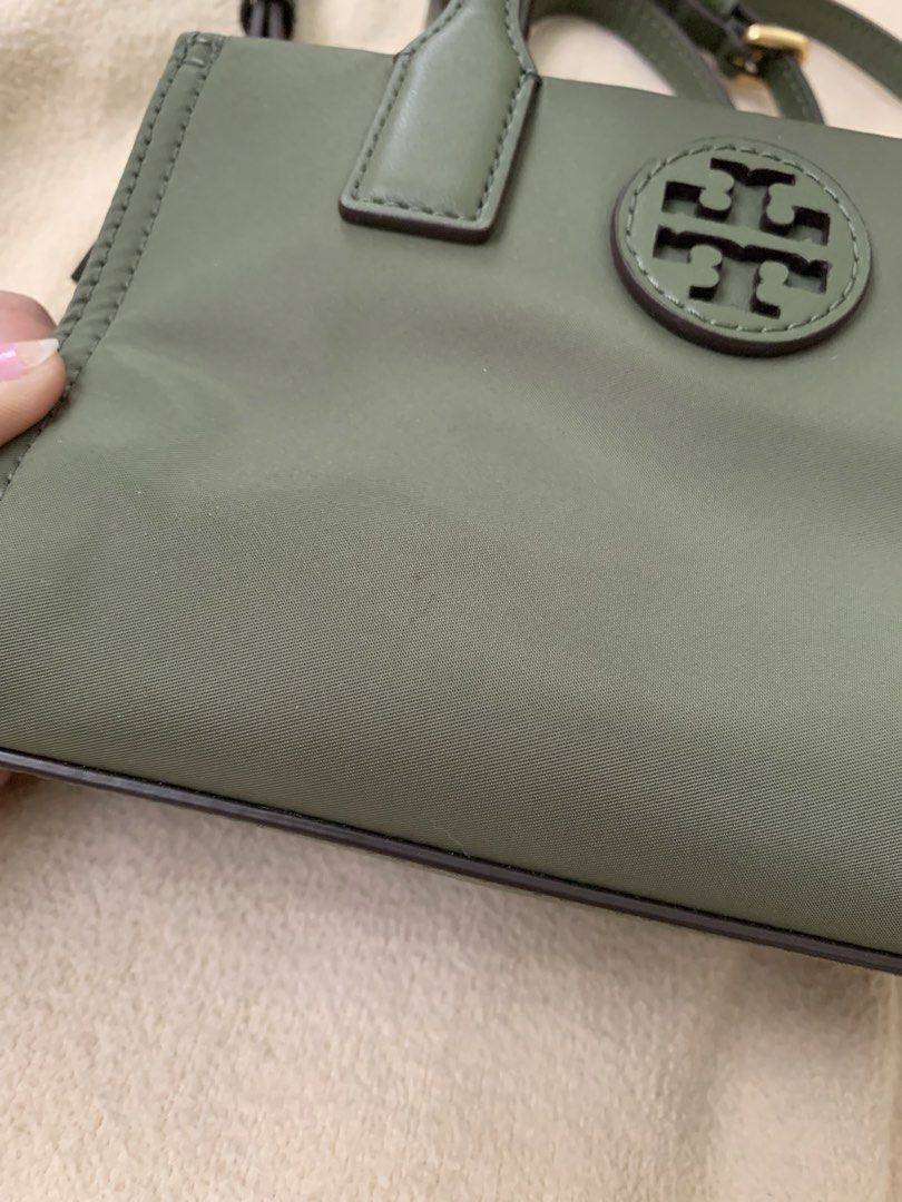 Authentic Tory Burch Mini Tote Ella Bag (Category: Luxury Bags & Wallets) located in Manila. Submitted by ilovepreloved.thine (Listing ID 1431016836, Image 2). Description: Mini tote bag features a green nylon exterior with a top handle and a detachable shoulder strap. It has a zip closure and a logo detail on the front. The interior is lined with a matching fabric. The bag includes gold-tone hardware and a small exterior pocket. The tag inside i