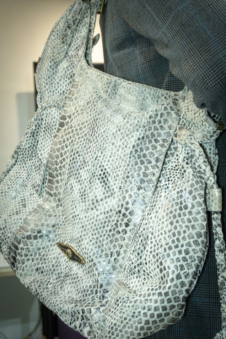 Elliott Lucca Snakeskin Hobo Bag (Category: Shoulder Bags) located in Silang. Submitted by melstore (Listing ID 1431104096, Image 1). Description: PRE LOVED ORIGINAL Elliott Lucca hobo bag features a snakeskin pattern in shades of gray and white. It has a single shoulder strap and a top zipper closure. The interior lining has a floral pattern and includes a zippered pocket. The bag has a gold-tone clasp with the brand name on it..
