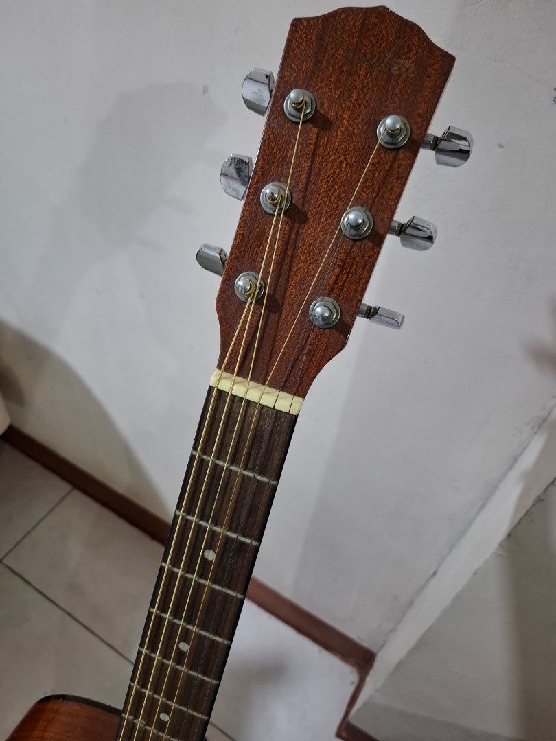 Fender CD-60/NAT Acoustic Guitar (Category: Musical Instruments) located in Mandaluyong City. Submitted by rehenami (Listing ID 1431131723, Image 3). Description: Fender CD-60/NAT acoustic guitar. Includes a guitar stand and a carrying case. The guitar has a natural finish. The headstock has six tuning pegs. The guitar has a black pickguard. The soundhole has a Fender label. The guitar is shown with a capo. With minimal scratches, not noticeable.