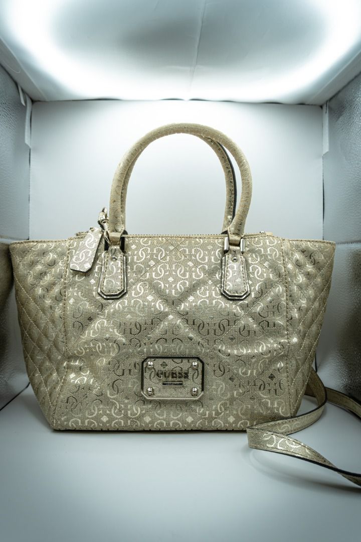 Guess Gold Handbag (Category: Shoulder Bags) located in Silang. Submitted by melstore (Listing ID 1431105706, Image 1). Description: PRE-LOVED ORIGINAL A Gold Guess handbag with a leopard print interior and a gold-toned hardware. Features a zippered closure and a magnetic snap closure on the front pocket. Interior includes a small zippered pocket. .