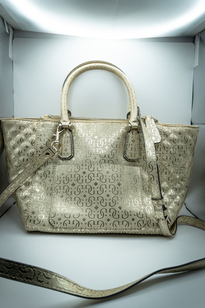 Guess Gold Handbag (Category: Shoulder Bags) located in Silang. Submitted by melstore (Listing ID 1431105706, Image 2). Description: PRE-LOVED ORIGINAL A Gold Guess handbag with a leopard print interior and a gold-toned hardware. Features a zippered closure and a magnetic snap closure on the front pocket. Interior includes a small zippered pocket. .