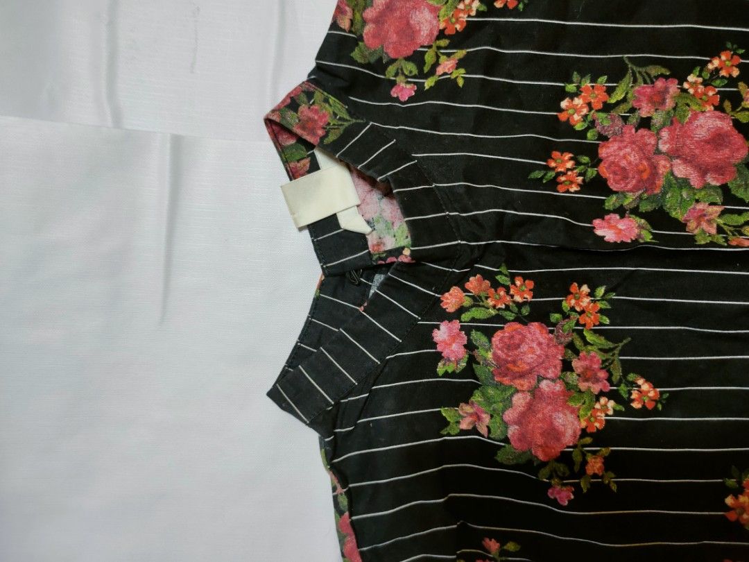 H&M Floral Striped Blouse Black (Category: Blouses) located in Marikina City. Submitted by styledandsassified (Listing ID 1431141378, Image 2). Description: H&M blouse features a black and white striped pattern with a floral design. It has short sleeves with ruffle details and a high neckline. The blouse has a split at the back. The tag indicates it is a size EUR 34..
