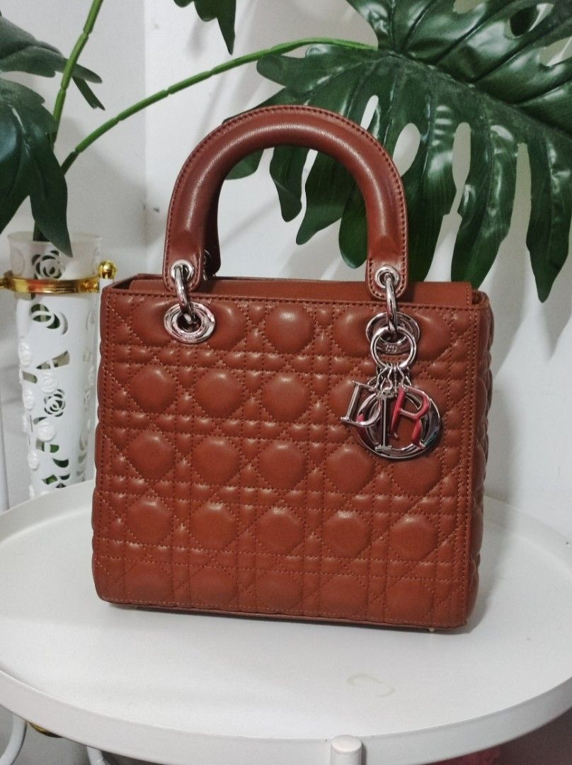 Lambskin Cannage Medium Lady Dior Brown (Category: Luxury Bags & Wallets) located in Santa Rosa. Submitted by sassycollection. (Listing ID 1431099540, Image 1). Description: CD Lambskin Cannage Medium Lady Dior in Brown. This chic tote is crafted of brown cannage quilted lambskin leather. The bag features sturdy leather top handles with gold hardware including hanging Dior logo charms and opens to a brown fabric interior with a patch and zipper p