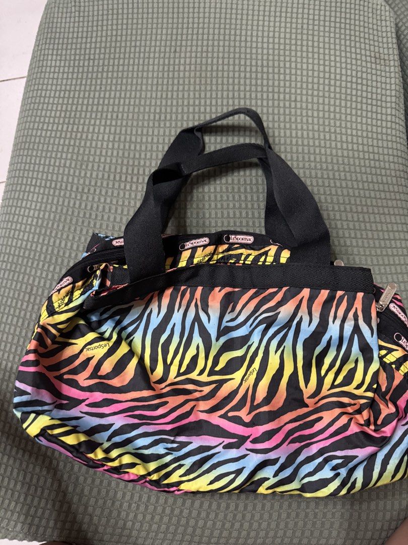 LeSportsac Rainbow Zebra Messenger Bag (Category: Tote Bags) located in Manila. Submitted by plusCize (Listing ID 1431121726, Image 1). Description: LeSportsac Rainbow Zebra Messenger Bag, a vintage piece featuring a colorful rainbow zebra exterior. .